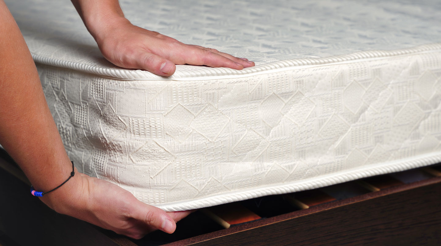 Trois sur-matelas d'épaisseurs croissantes (2-3 cm, 4-5 cm, 6-8 cm) alignés côte à côte en vue de profil sur une table de showroom